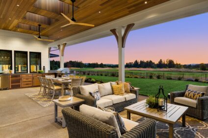 Luxury home exterior at sunset: Outdoor covered patio with kitch